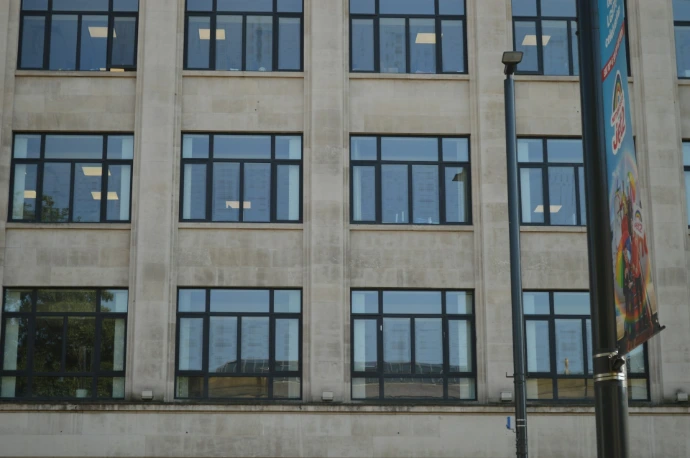 A concrete building facade with many windows and a lamppost